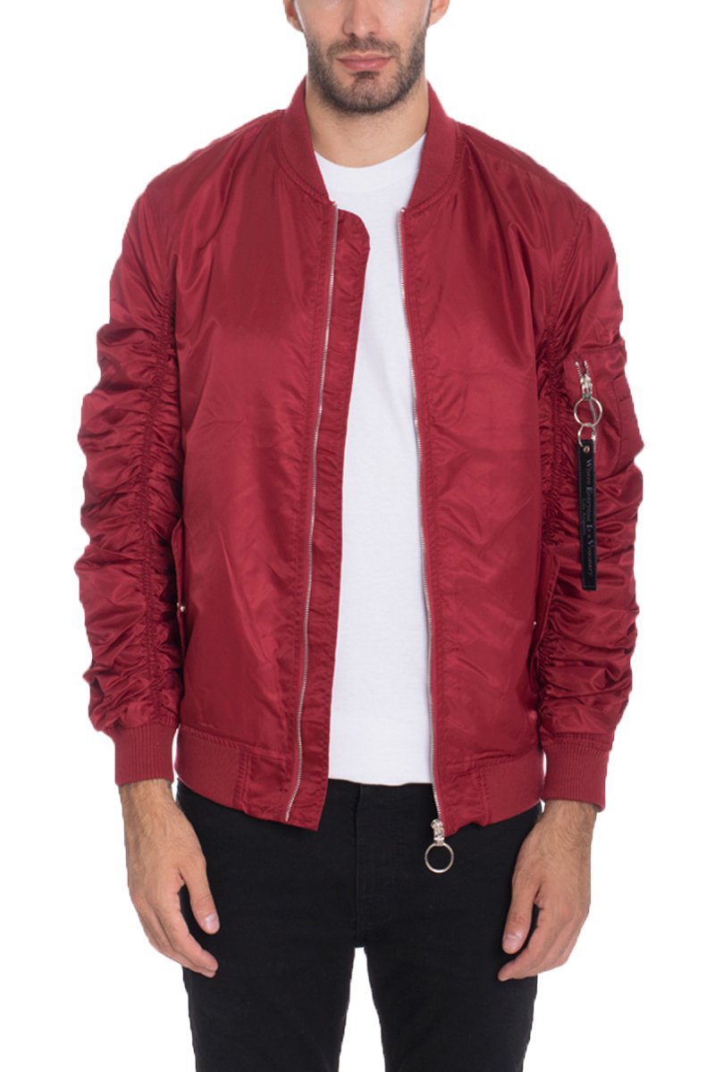 A man wears the Lime Milo FLIGHT LINED BOMBER 6116 in shiny red with scrunched sleeves, over a white t-shirt and black pants, standing forward with arms relaxed by his sides.