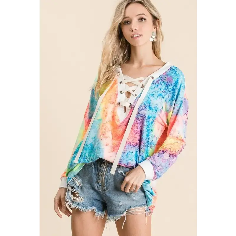 BiBi Tie Dye Deep V-neck Top With Lace Up Front in vibrant colors paired with denim shorts.