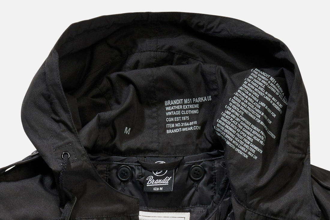 Close-up of the inside hood of a black Callisto M51 US Parka Jacket, showing size M tags, care instructions, and the brand label printed in white on the inner fabric.
