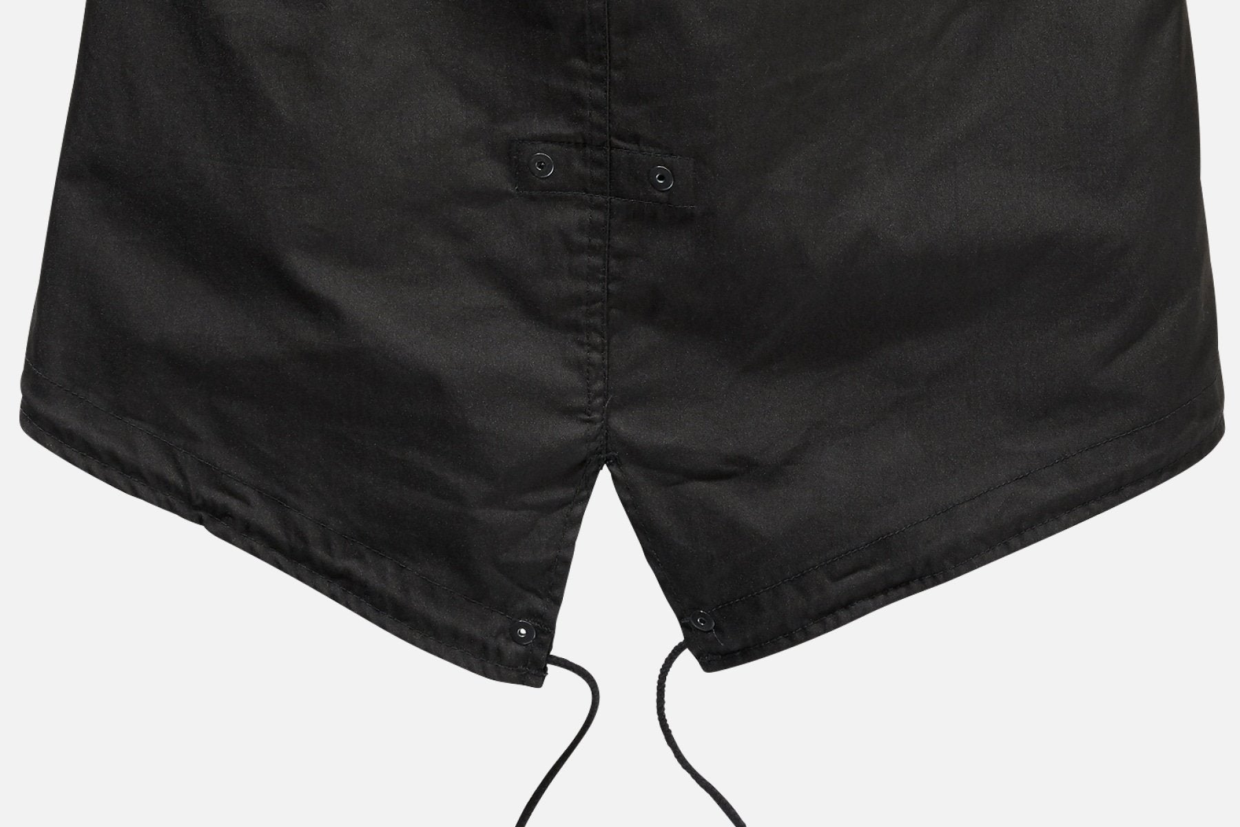 Close-up of the hem of the Callisto M51 US Parka Jacket in black, showcasing its military fishtail design with snap buttons and two drawstrings hanging down.